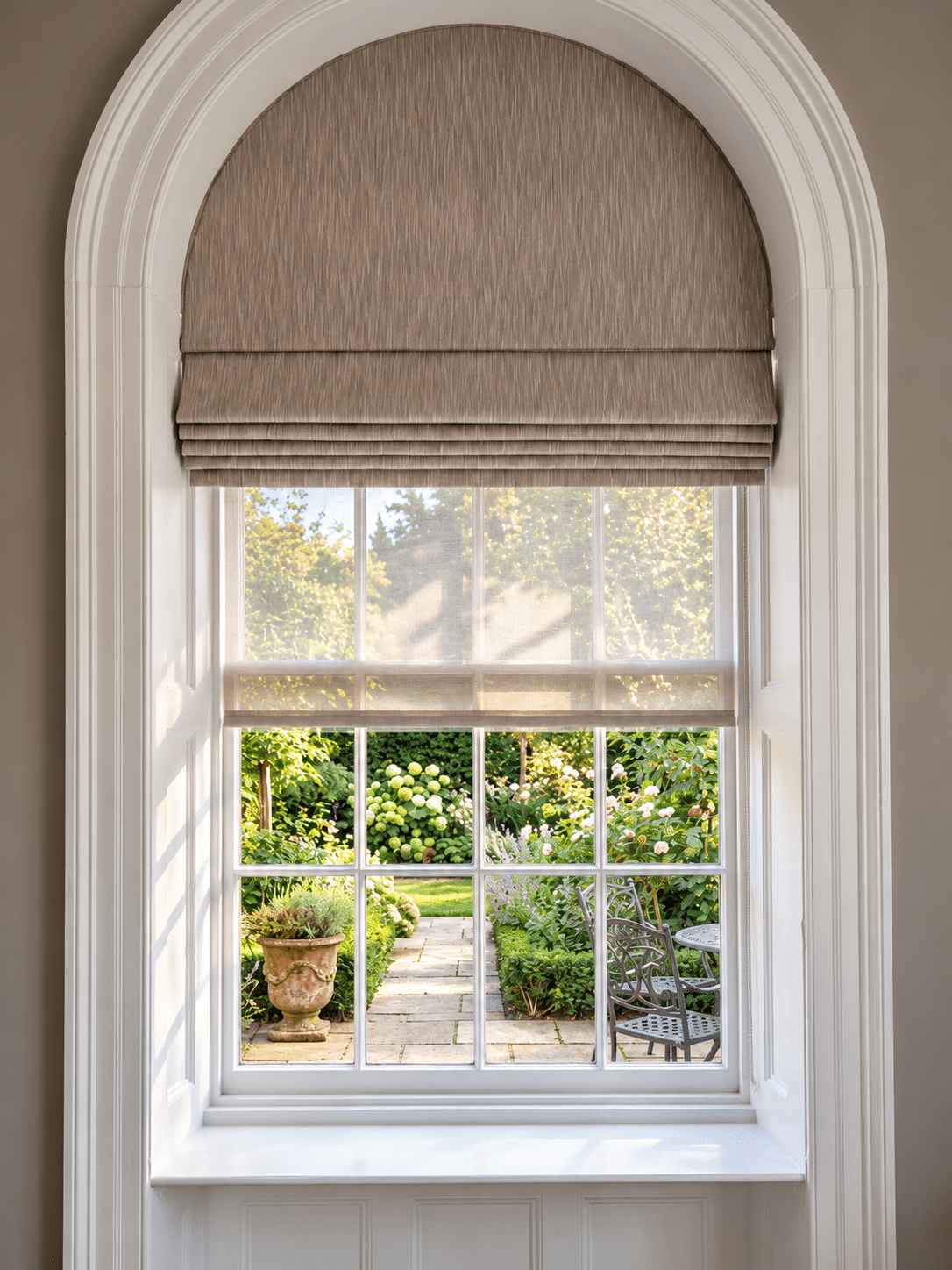 Made-to-measure motorised Roman blind shaped to fit an arched window